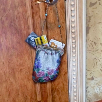 A trompe l'oeil purse painted on the back of a door.