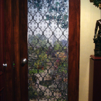 A trompe l'oeil door gives the illusion of a leaded window.